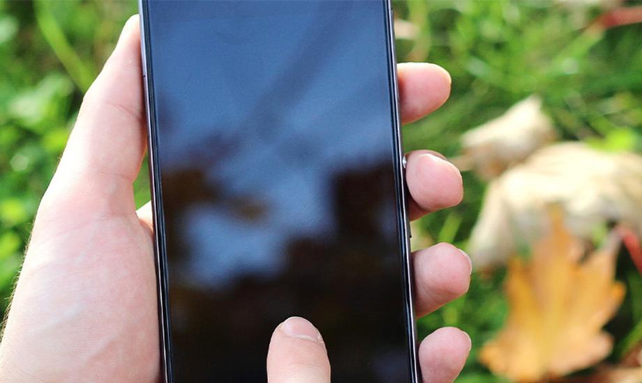 Someone holding a phone. the screen is black and blank